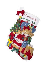 Bucilla felt christmas stocking kit. Design features a Mama bear reading a story to her two baby cubs. the background is a living room setting.