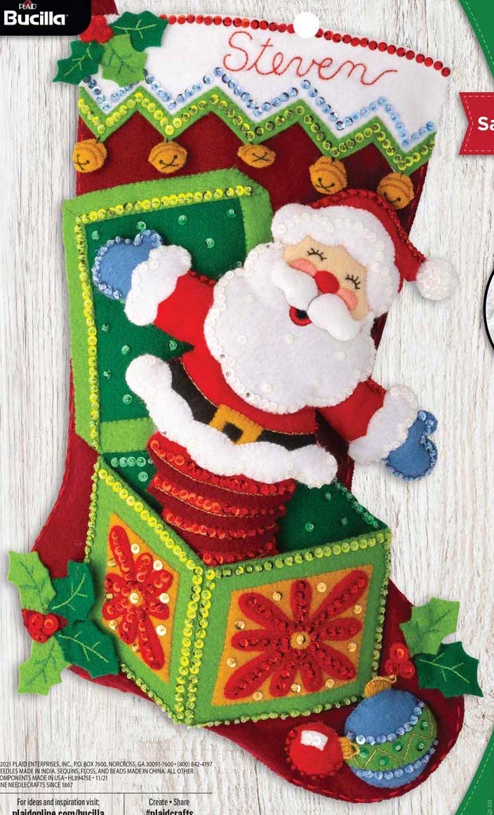 Bucilla felt christmas stocking kit. The design features a santa jack in the box. Christmas decorations in the background.