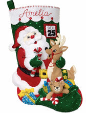 Load image into Gallery viewer, Bucilla felt christmas stocking kit. Design features santa with his bag of toys  and a reindeer. Calendar with Dec 25 in the background.
