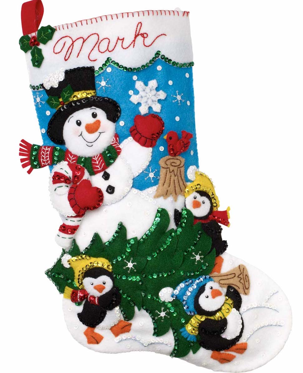 Bucilla felt christmas stocking kit. Design features a snowman waving as three penguins carry a cut christmas tree through the snow.