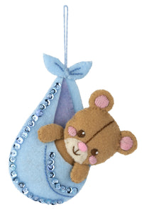 Teddy bear inside of a hanging bundle.