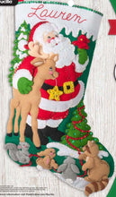 Load image into Gallery viewer, Bucilla Felt Stocking Kit. The design is Santa and his reindeer standing in the forest with some woodland animals. Christmas tress in the background.