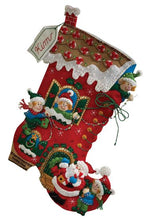 Load image into Gallery viewer, Bucilla christmas Felt stocking kit. Design features an elf house shaped like a big red boot. The elves are decorating their house with santa helping.