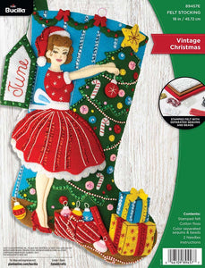 Bucilla felt christmas stocking kit. Design features a vintage style woman decorating a tree.