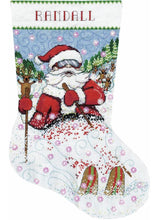 Load image into Gallery viewer, Counted cross stitch christmas stocking kit. The design features Santa  skiing through the snow. Reindeer in the background. 