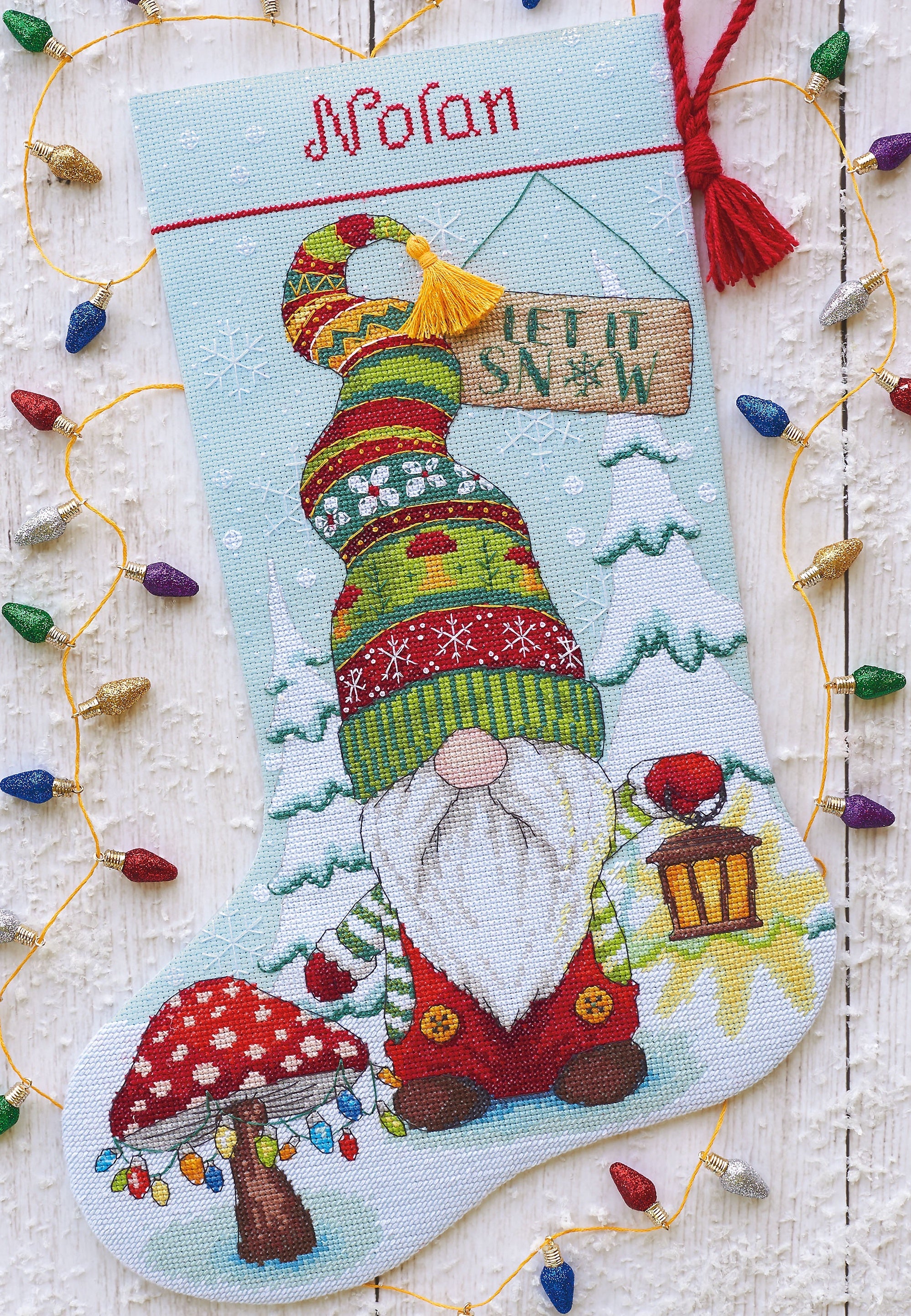 Dimensions counted cross stitch stocking kit. Design features a gnome with a lantern and a mushroom tree with lights.
