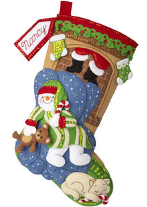 Bucilla felt stocking kit. Design features a  living room scene with a sleeping snowman holding a teddy bear. A cat lays nearby and santa in on his way down the chimney.