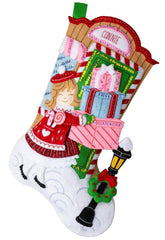 Bucilla felt Stocking kit. design features a girl carrying gifts in front of a store.