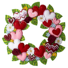 Load image into Gallery viewer, Bucilla felt wreath kit. Design features red, pink and white hearts mixed with blue and white flowers.