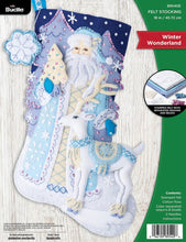 Load image into Gallery viewer, ucilla felt christmas stocking kit. Design features a santa dressed in light blue and cream next to a white deer. The background features light purple trees. Blues and Purples are predominant in this stocking. 